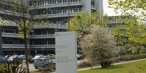 Das Gebäude an der Emil-Figge-Straße 50 mit einer Stele im Vordergrund.